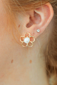 girl wearing gold flower earring with pearl 