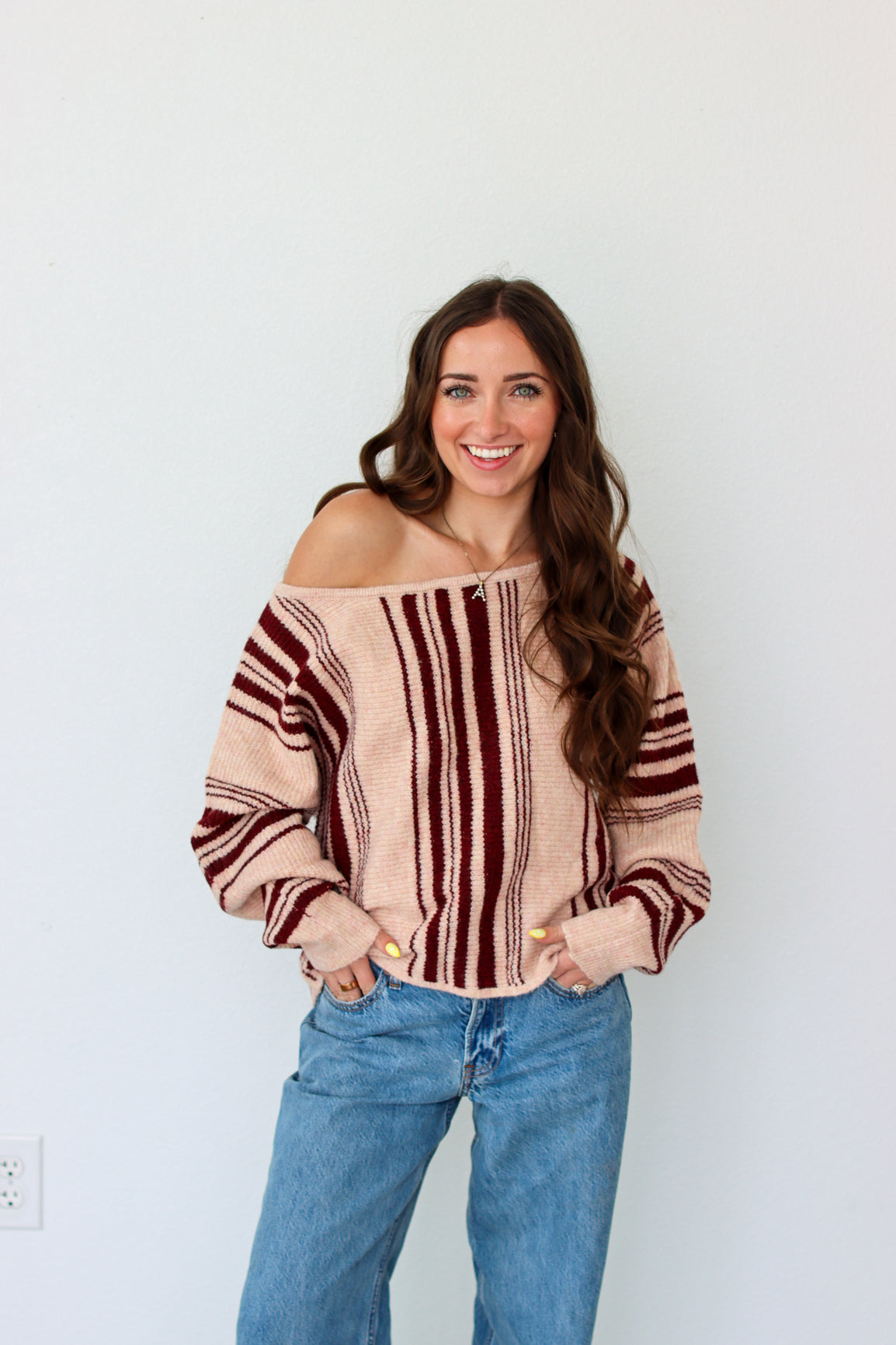 Woman wearing a dark red striped off the shoulder top 