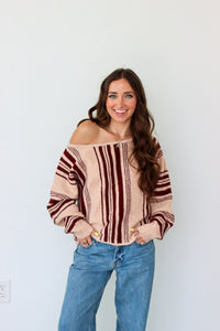 Woman wearing a dark red striped off the shoulder top 