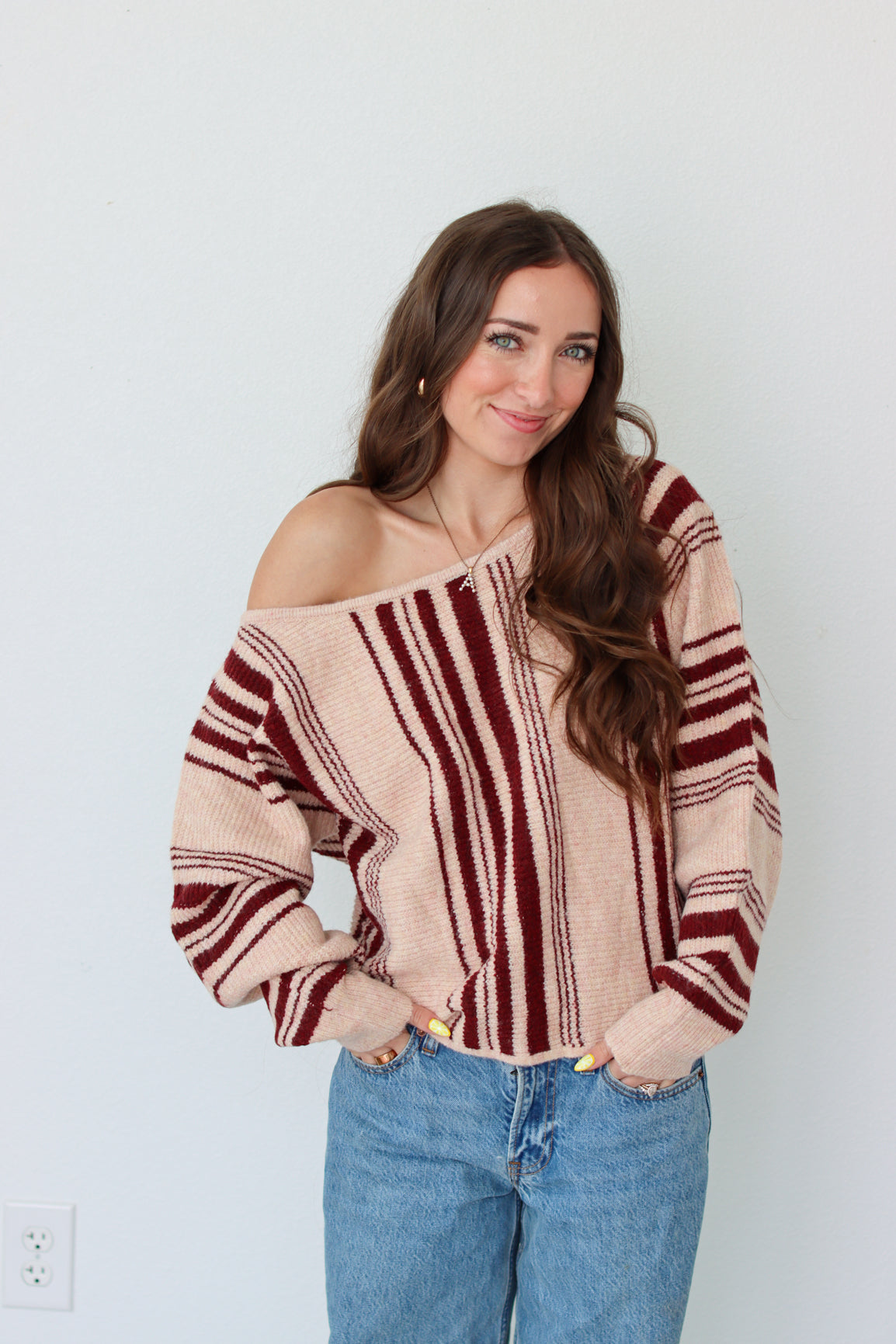 Woman wearing a dark red striped off the shoulder top 
