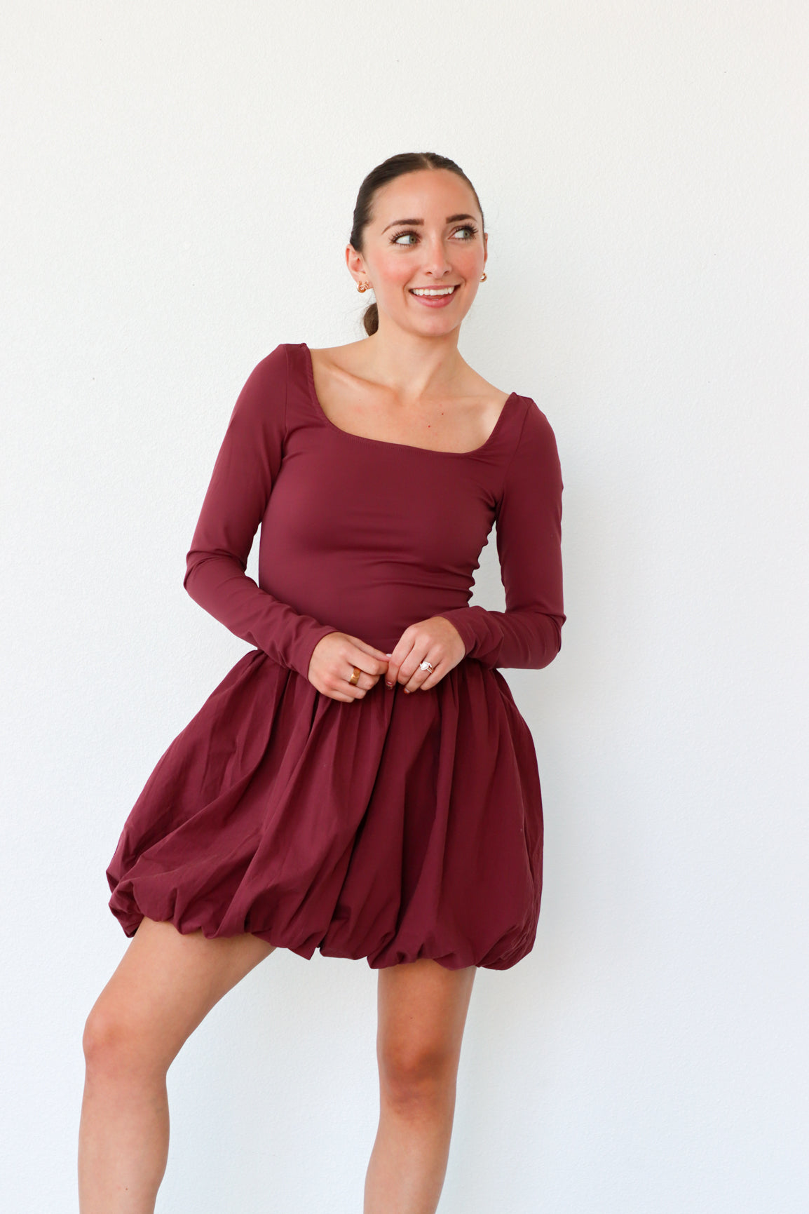 Woman wearing a burgundy dress against a white background