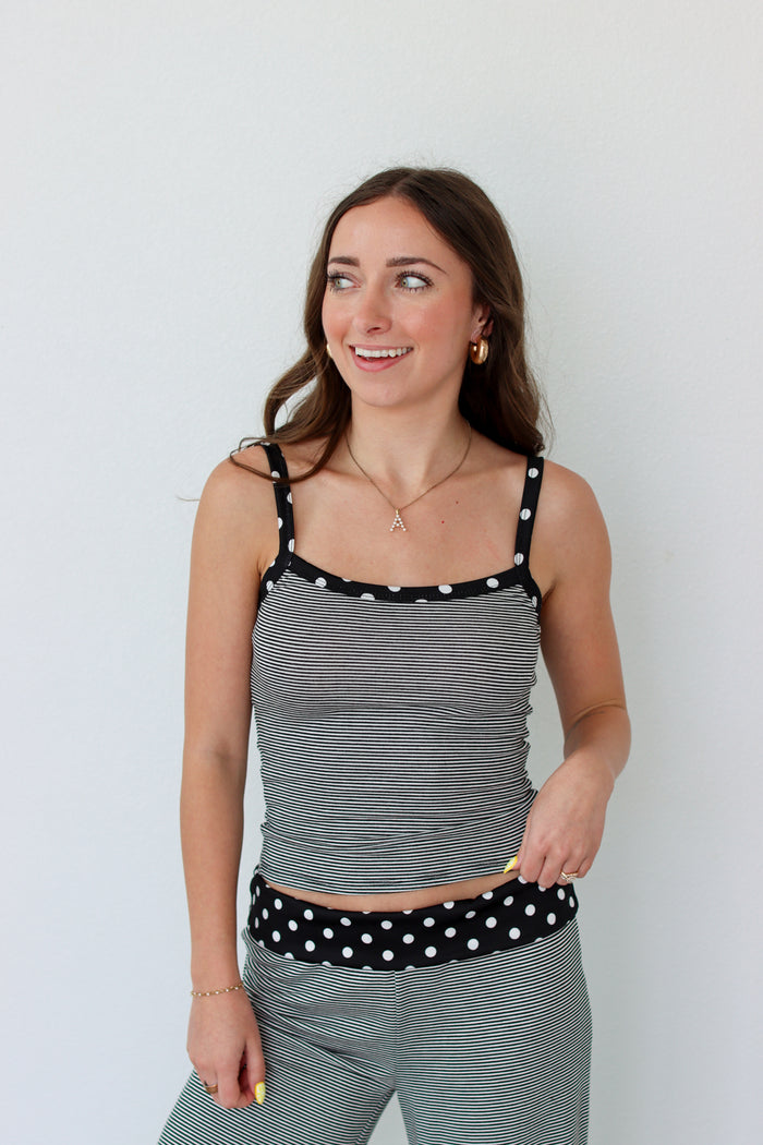 Woman wearing a black and white striped polka dot outfit set 