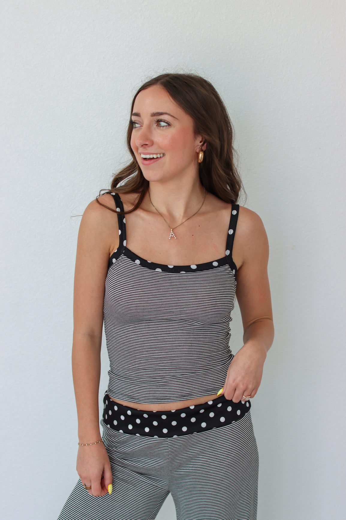 Woman wearing a black and white striped polka dot outfit set 