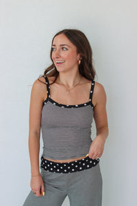 Woman wearing a black and white striped polka dot outfit set 