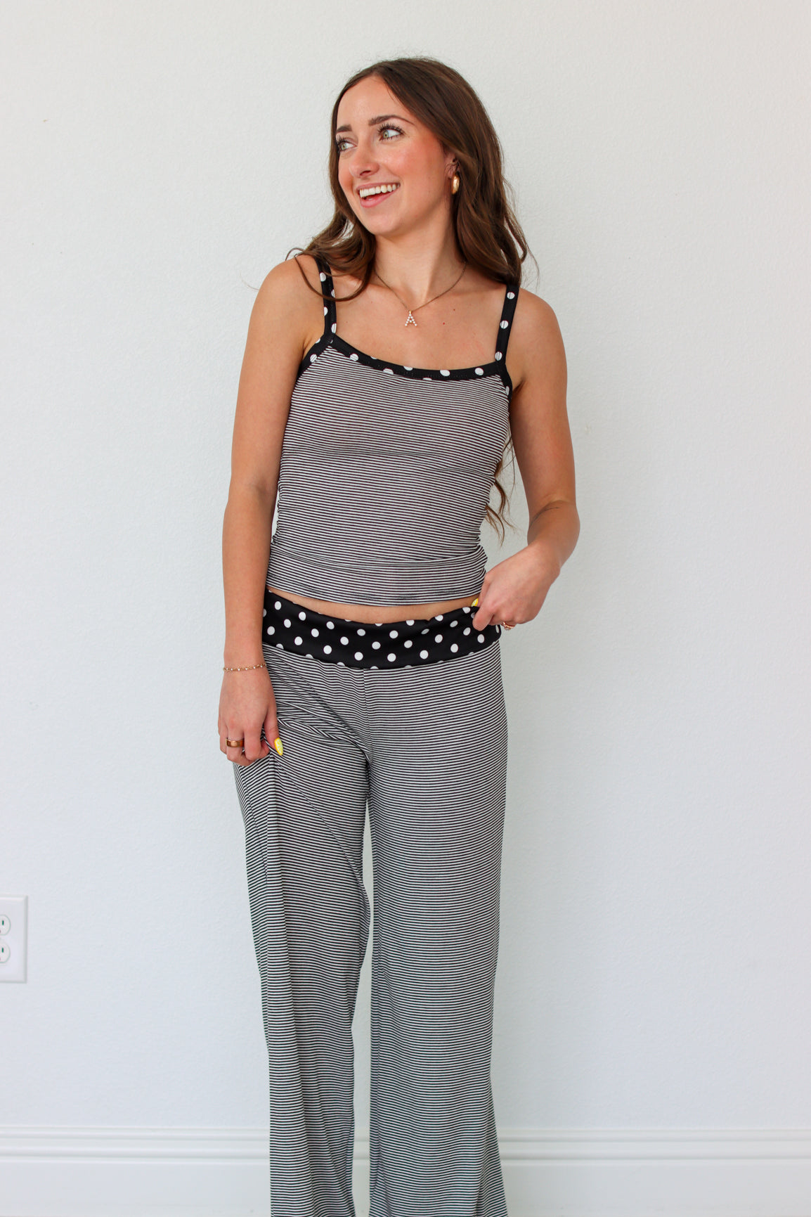 Woman wearing a black and white striped polka dot outfit set 