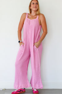 Woman wearing a pink jumpsuit against a white background