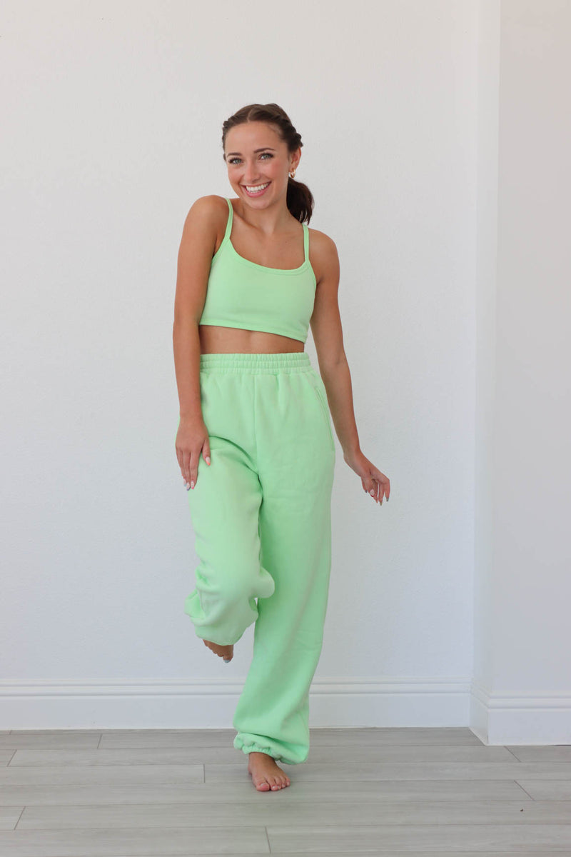 girl wearing lime green matching lounge set: sports bra and sweatpants