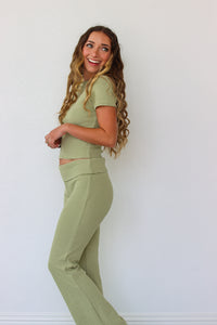 Woman wearing a green striped outfit against a white background