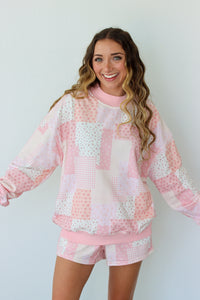 Woman wearing a pink and white outfit against a plain background