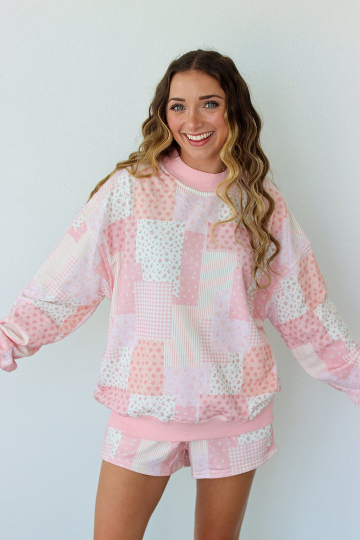 Woman wearing a pink and white outfit against a plain background