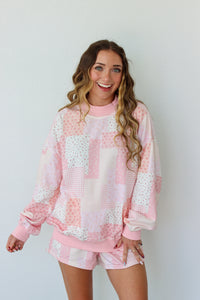 Woman wearing a pink and white outfit against a plain background