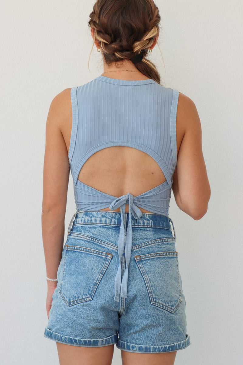 girl wearing light blue tank top with open back detailing