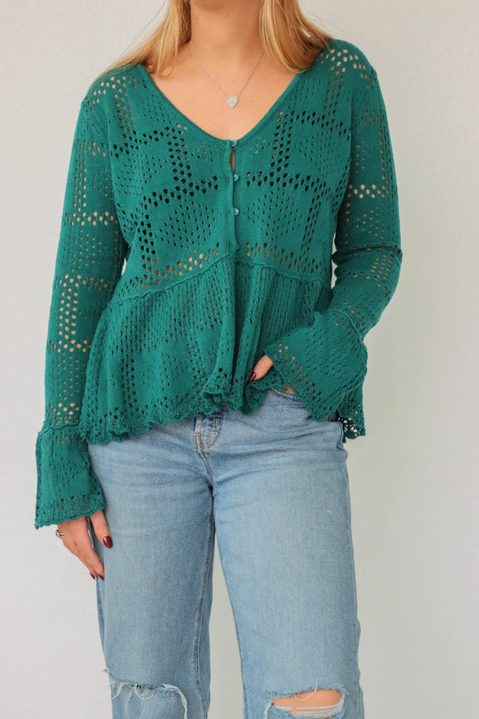 girl wearing teal crochet long sleeved top