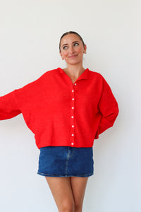 Woman wearing a red shirt and blue skirt against a white background