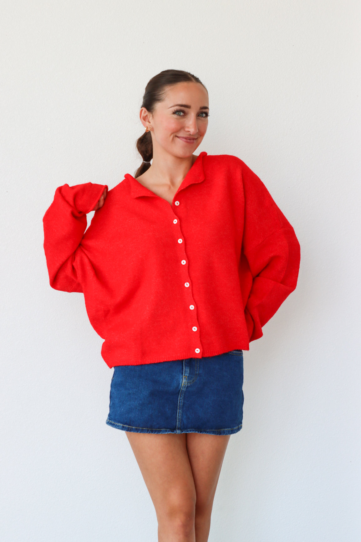 Woman wearing a red shirt and blue skirt against a white background