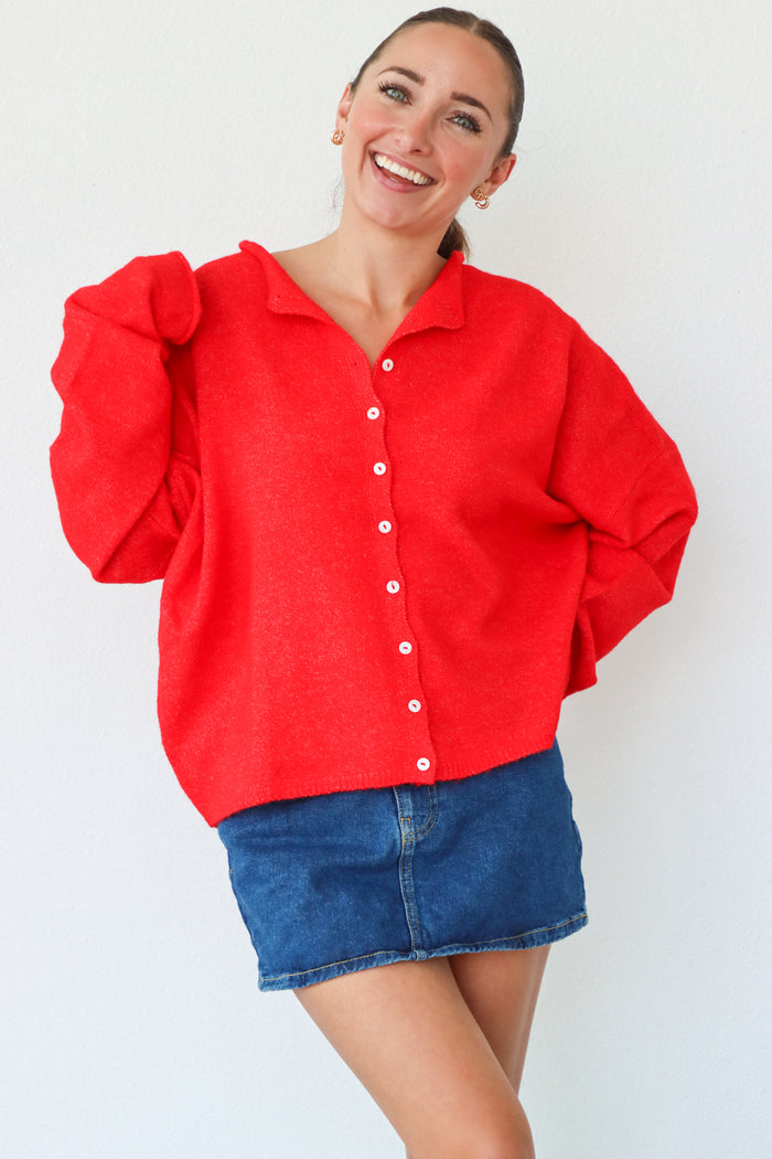 Woman wearing a red shirt and blue skirt against a white background