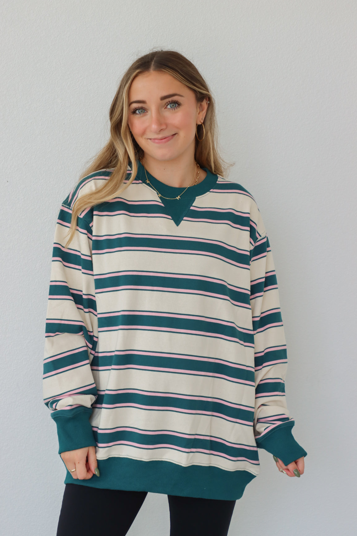 girl wearing teal and cream long sleeve top