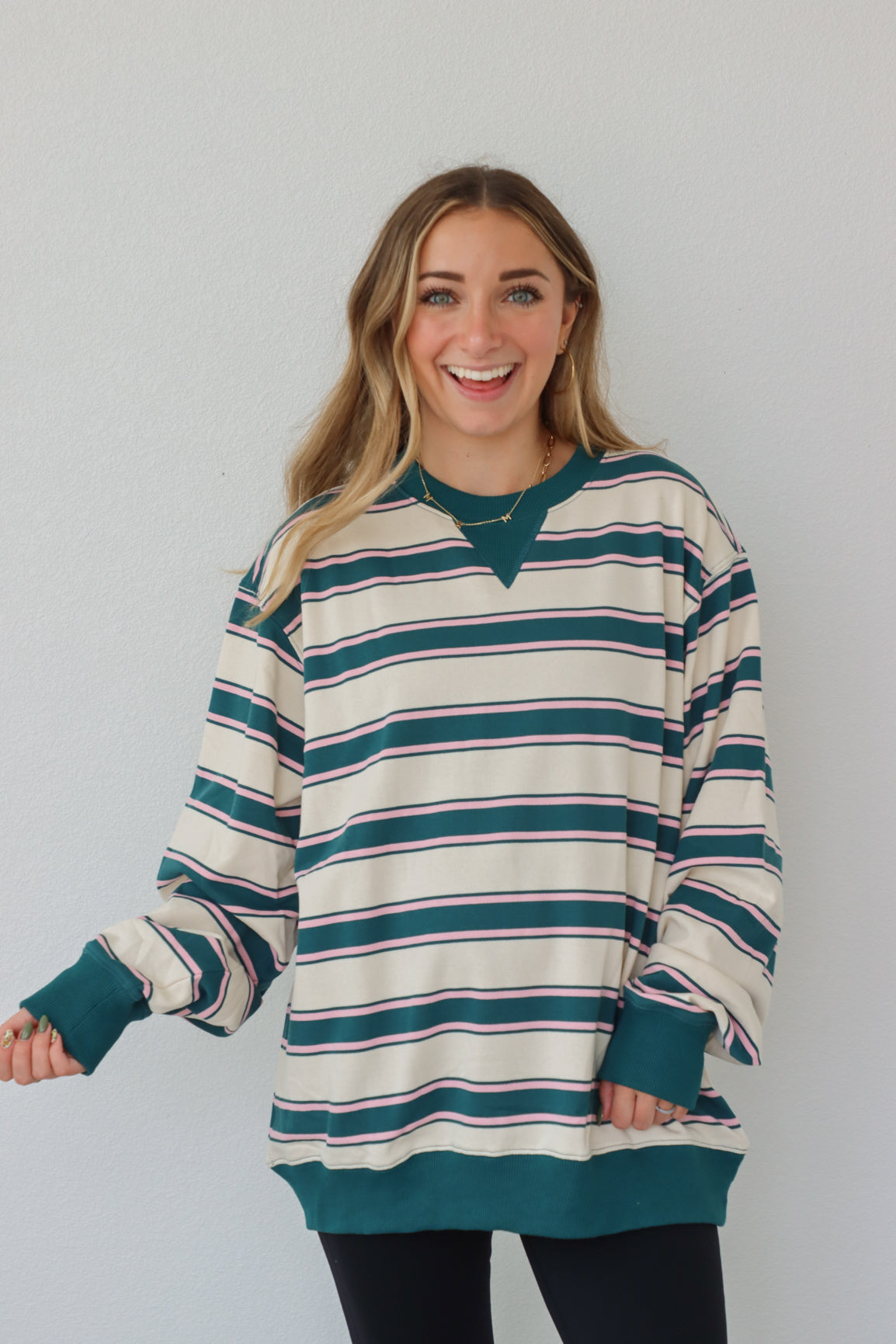 girl wearing teal and cream long sleeve top