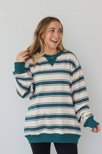 girl wearing teal and cream long sleeve top