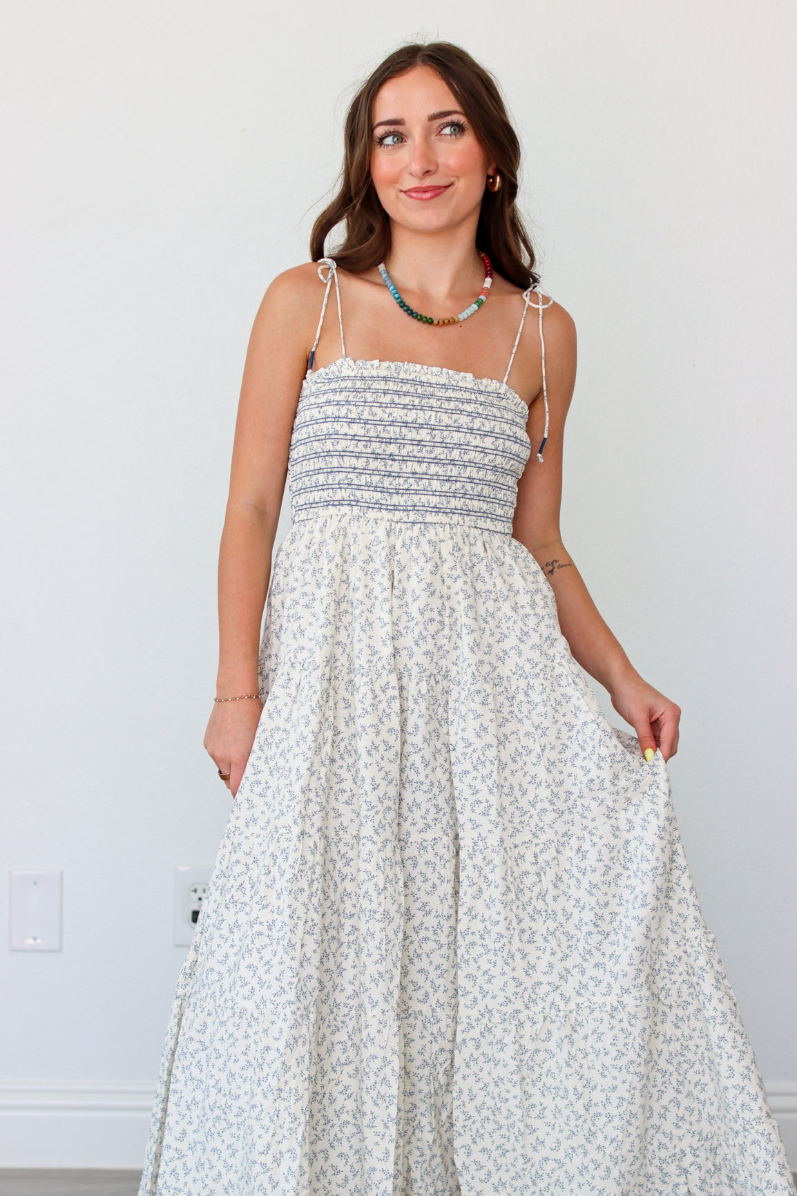 Woman wearing a light blue floral maxi dress against a white background 