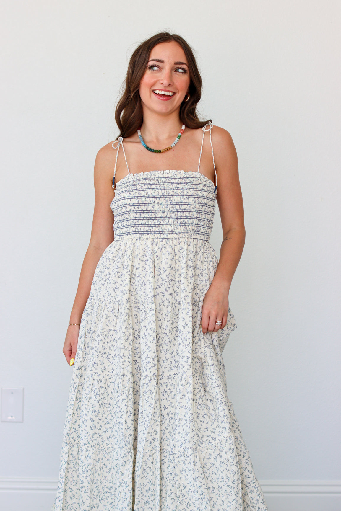 Woman wearing a light blue floral maxi dress against a white background 