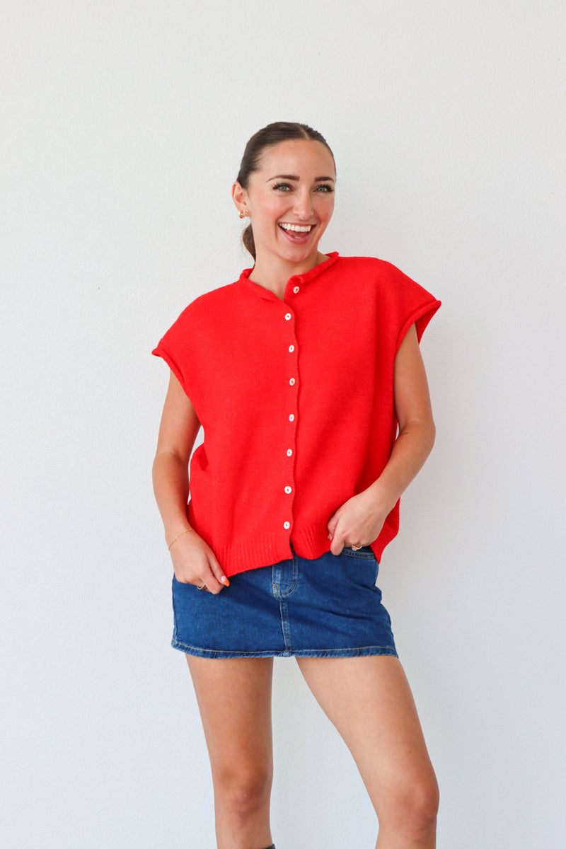 Woman wearing a red blouse and blue skirt against a white background