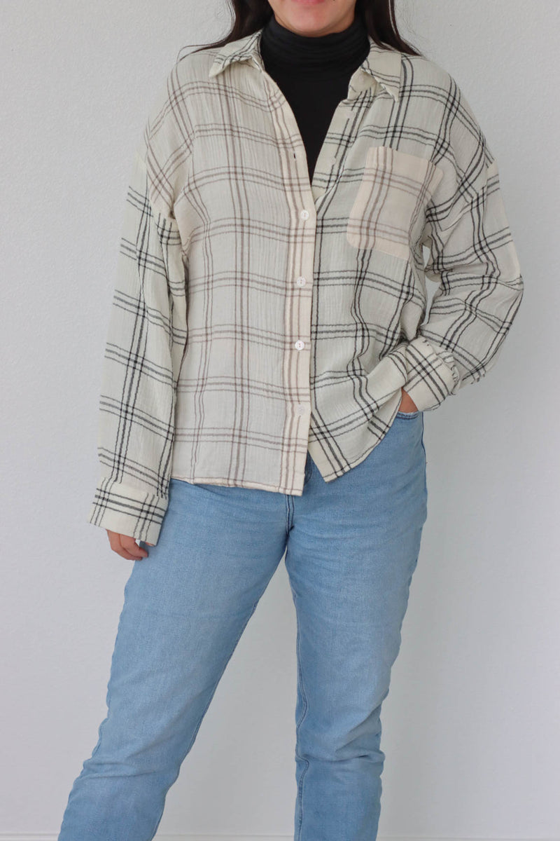 girl wearing cream plaid button up top