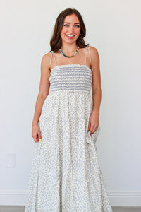 Woman wearing a light blue floral maxi dress against a white background 