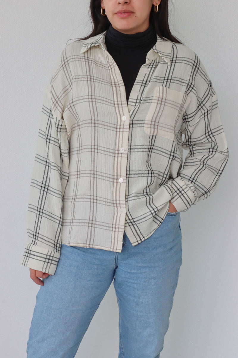 girl wearing cream plaid button up top