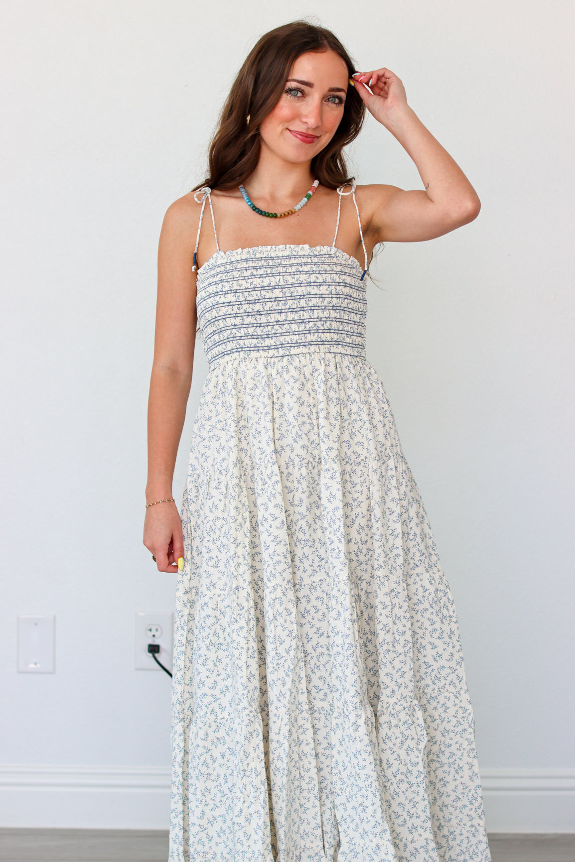 Woman wearing a light blue floral maxi dress against a white background 