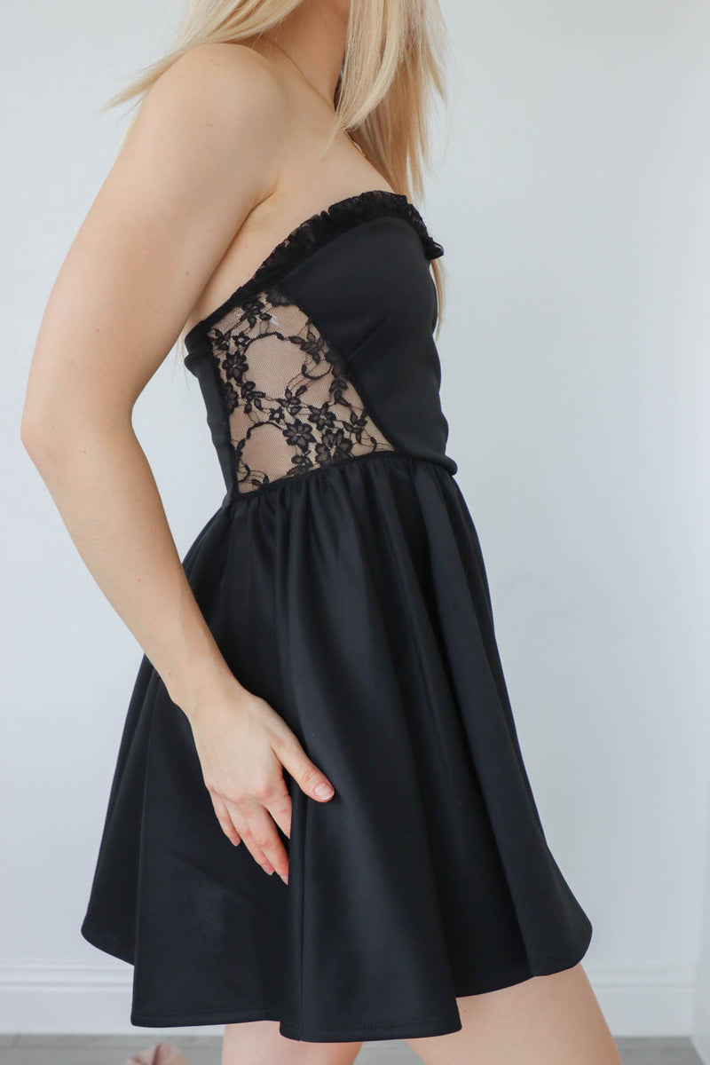 girl wearing black short strapless dress with lace detailing