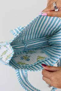 Close-up of a fabric basket with blue and white striped interior and floral exterior.