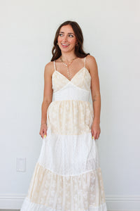 Woman wearing a white tiered maxi dress against a white background 
