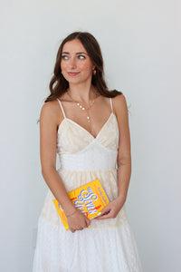 Woman wearing a white tiered maxi dress against a white background 