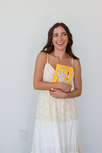 Woman wearing a white tiered maxi dress against a white background 