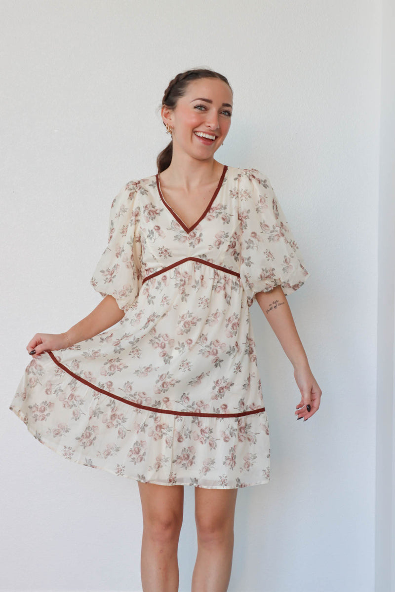 girl wearing cream and red floral dress