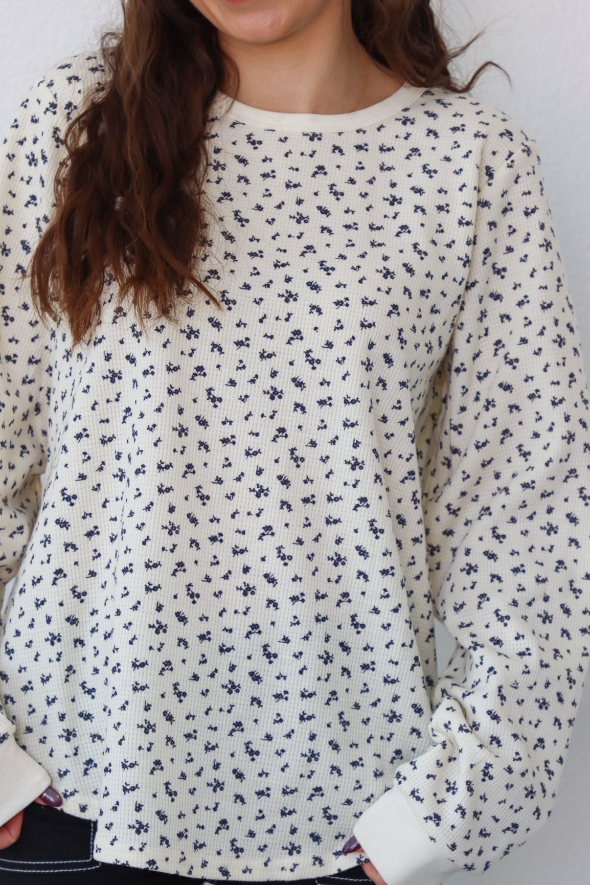 girl wearing cream long sleeve top with floral pattern