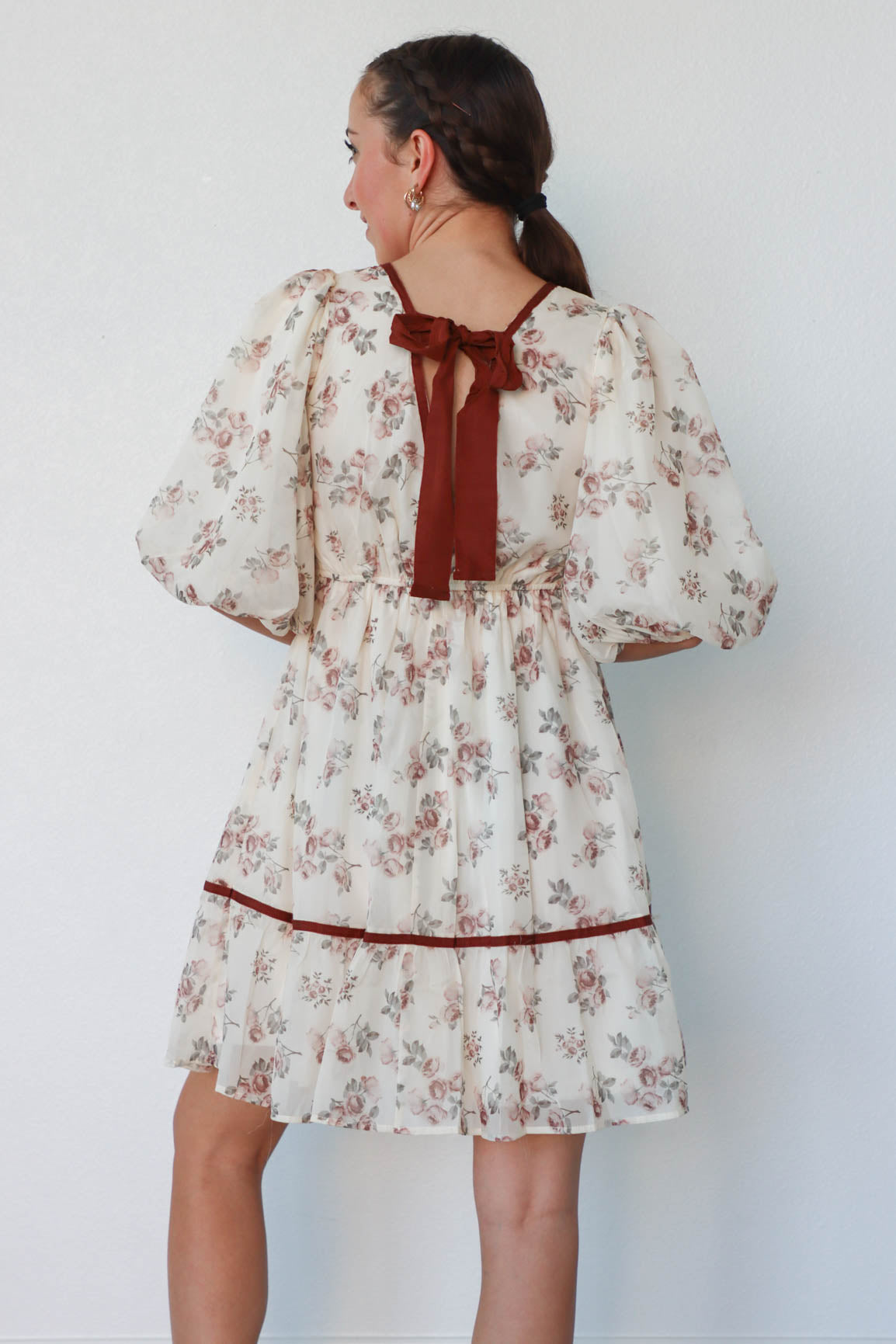 girl wearing cream and red floral dress