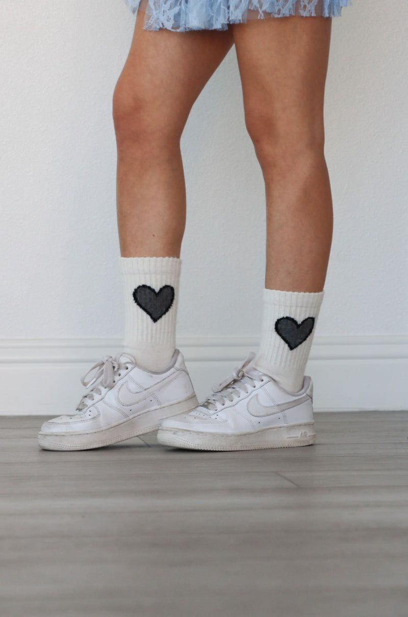 girl wearing white socks with black heart