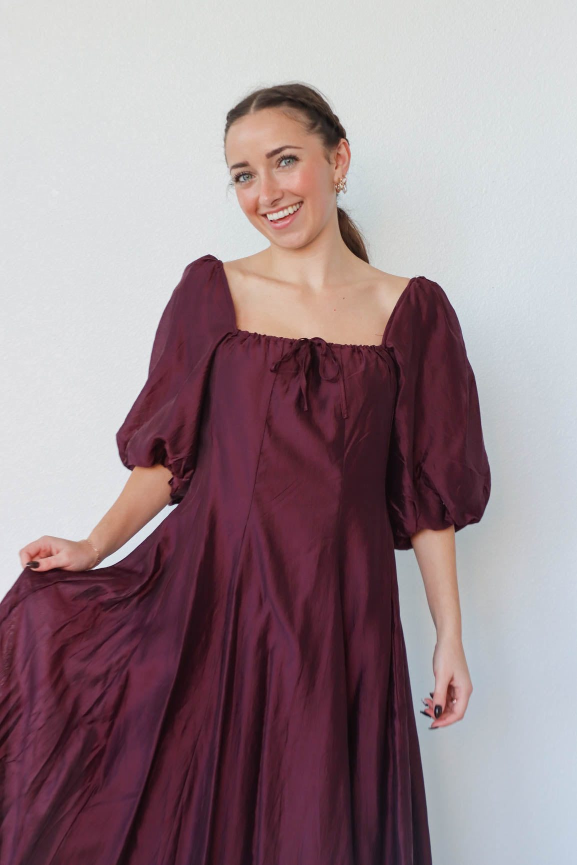 girl wearing long dark purple dress with 3/4 puff sleeves