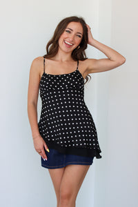 Woman wearing a black polka dot top with a denim mini skort 
