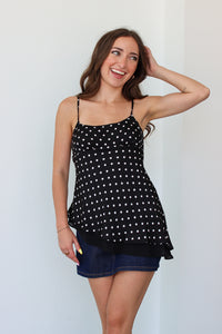 Woman wearing a black polka dot top with a denim mini skort 
