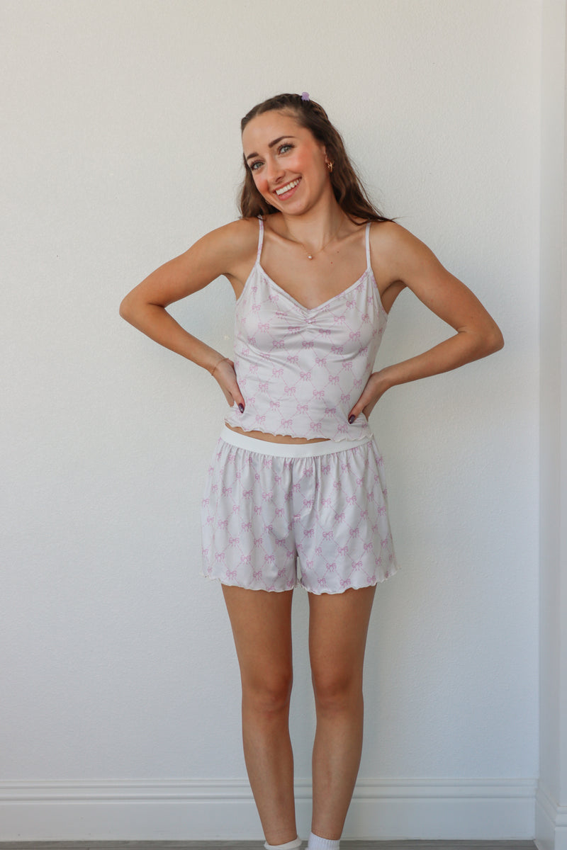 girl wearing white and light pink bow pj set