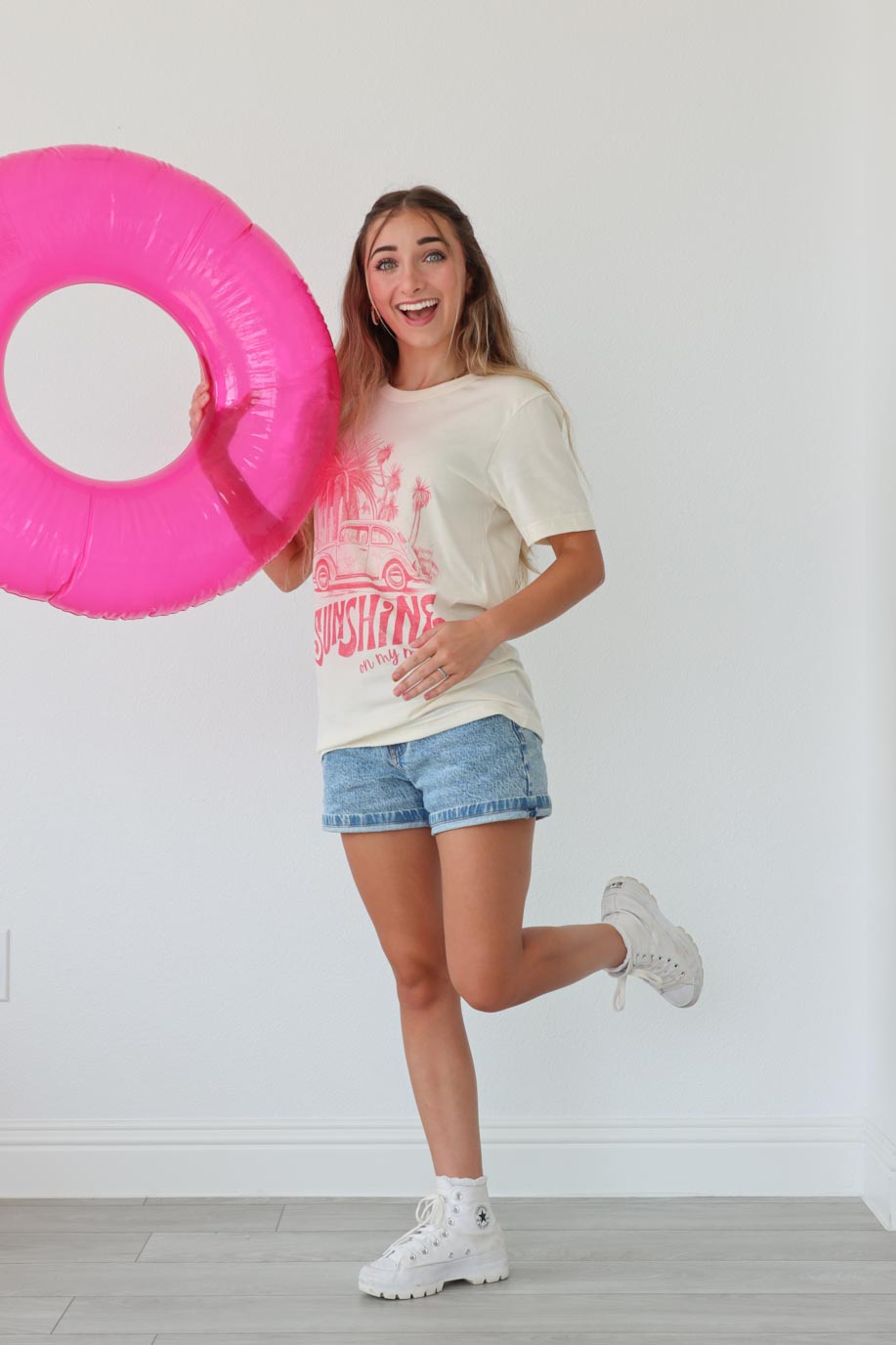 girl wearing cream t-shirt with pink "sunshine on my mind" graphic