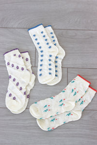 3 pairs of socks in purple, blue and red displayed on the floor