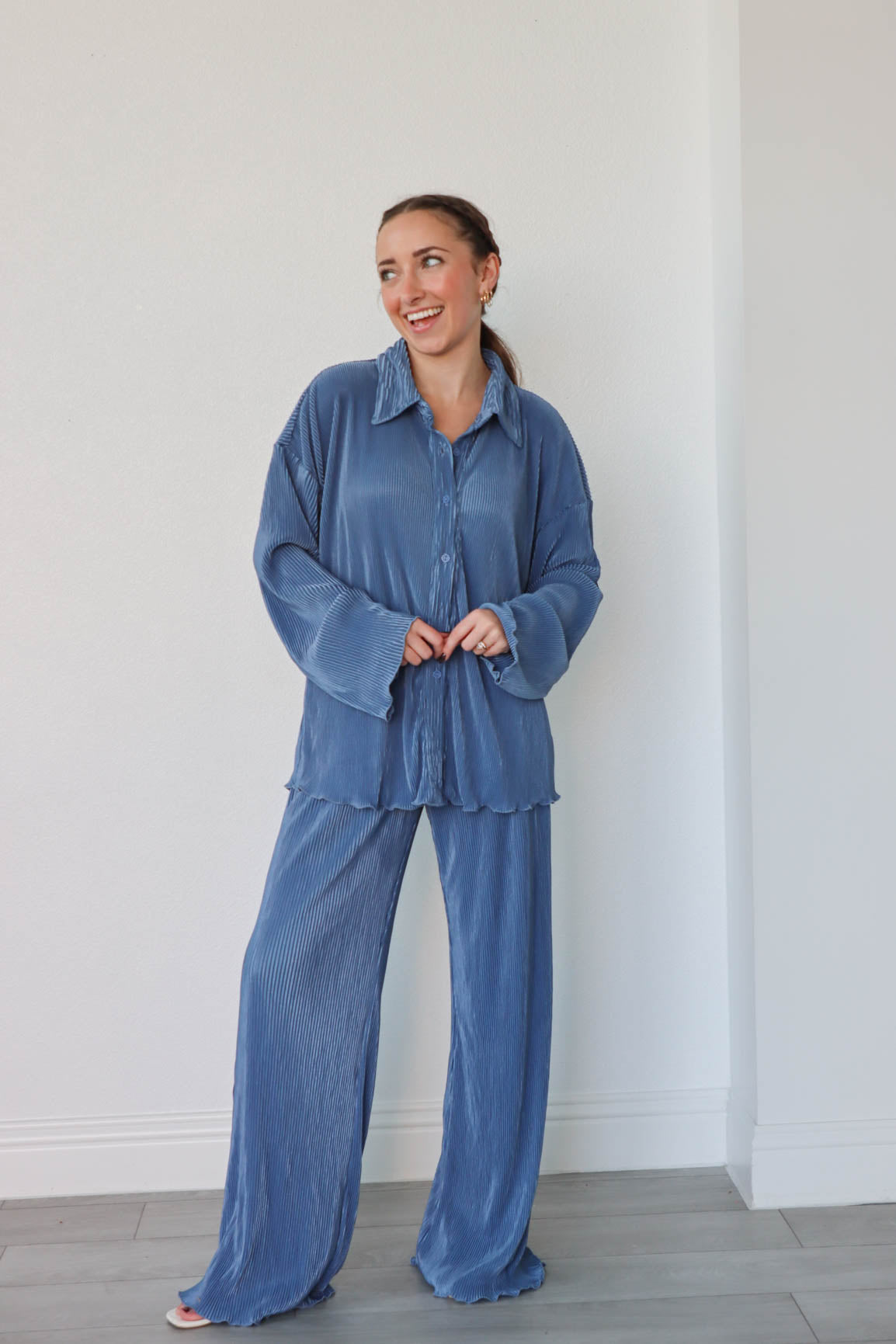 girl wearing denim blue outfit set with long sleeve button down blouse and elastic waist palazzo pants. Both in a pleated crinkle fabric