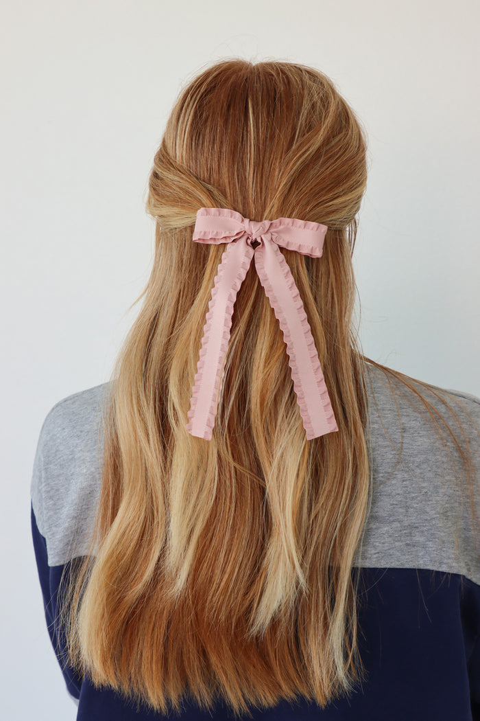 girl wearing light pink hair bow