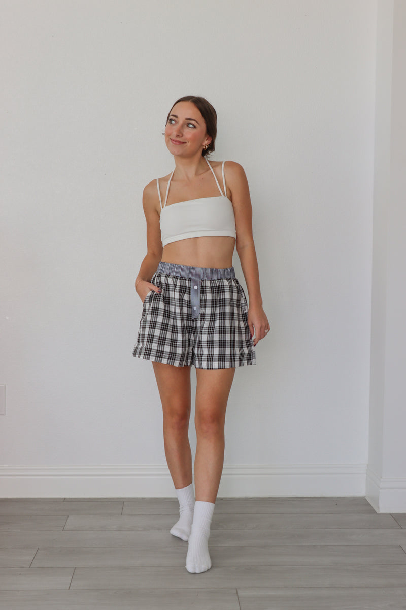 girl wearing black, white, and blue plaid boxer shorts