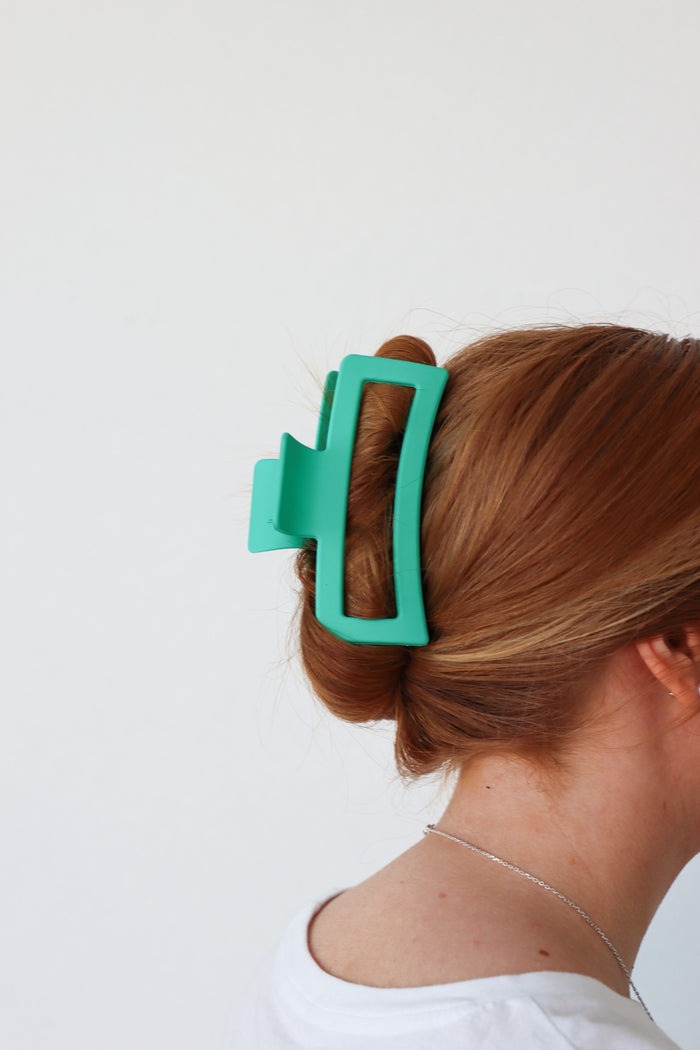 girl wearing green large clip in her hair