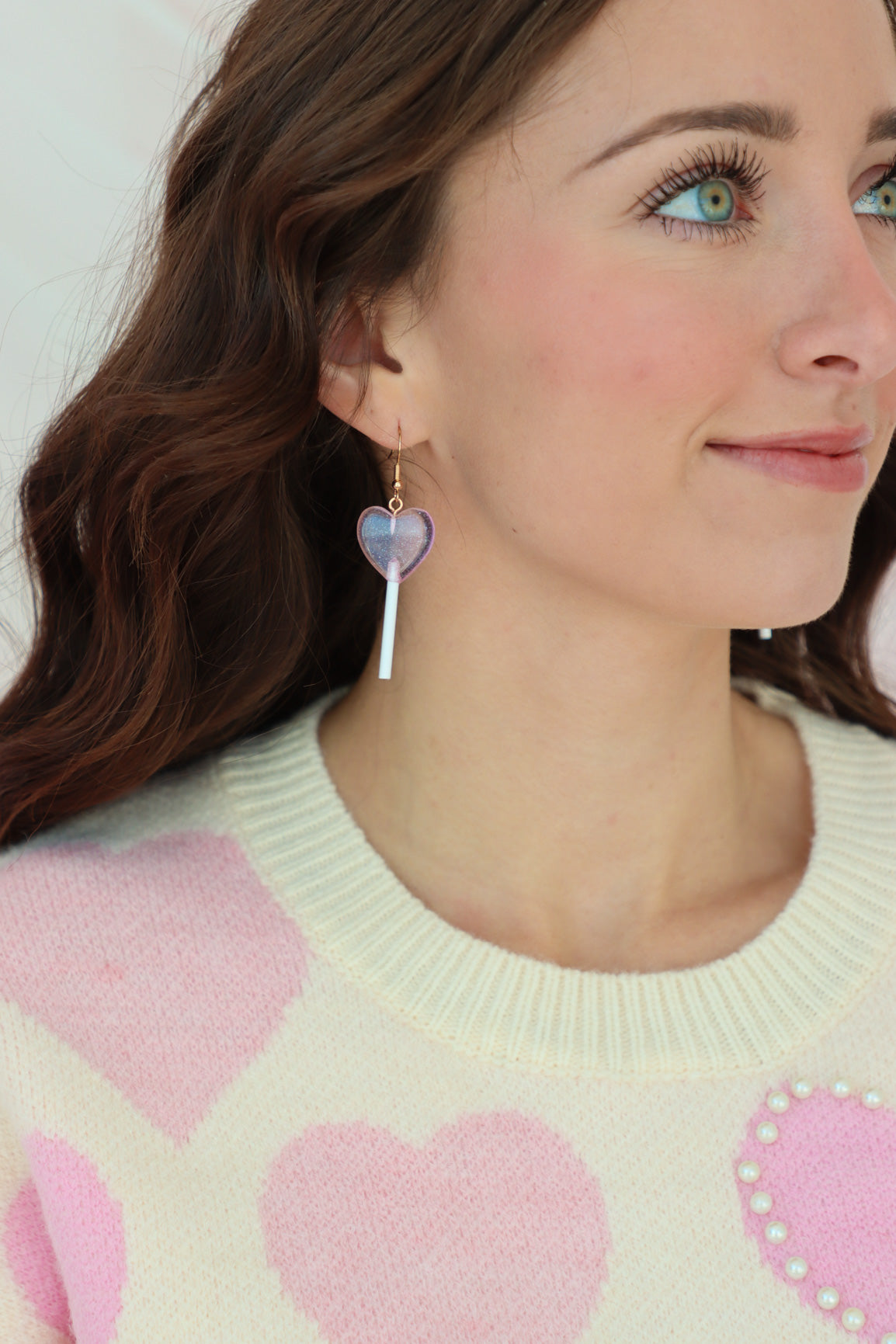 girl wearing pink heart-shaped lollipop earrings